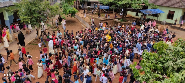 മാവേലിത്തമ്പുരാൻ കുട്ടികൾക്ക് മധുരം നൽകുന്നു.