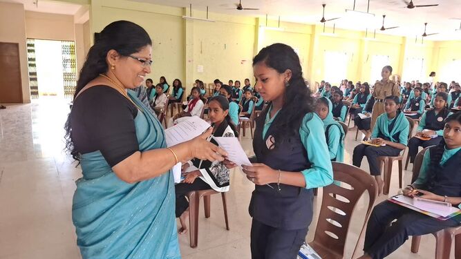 പ്രഥമ അധ്യാപിക ശ്രീമതി രമണി മുരളി ചോദ്യപേപ്പറുകൾ കൈമാറുന്നു
