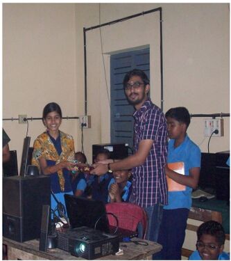 അസ്ന അഖിലിന് ഉപഹാരം നൽകുന്നു